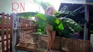 Rural striptease. Country girl dancing in the yard of her house Rustic striptease with banana leaf